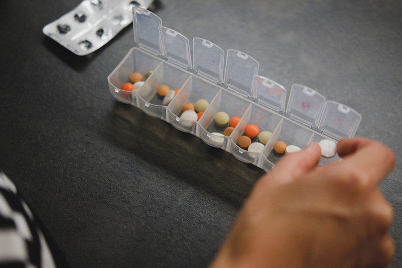 Hand filling a daily pill container