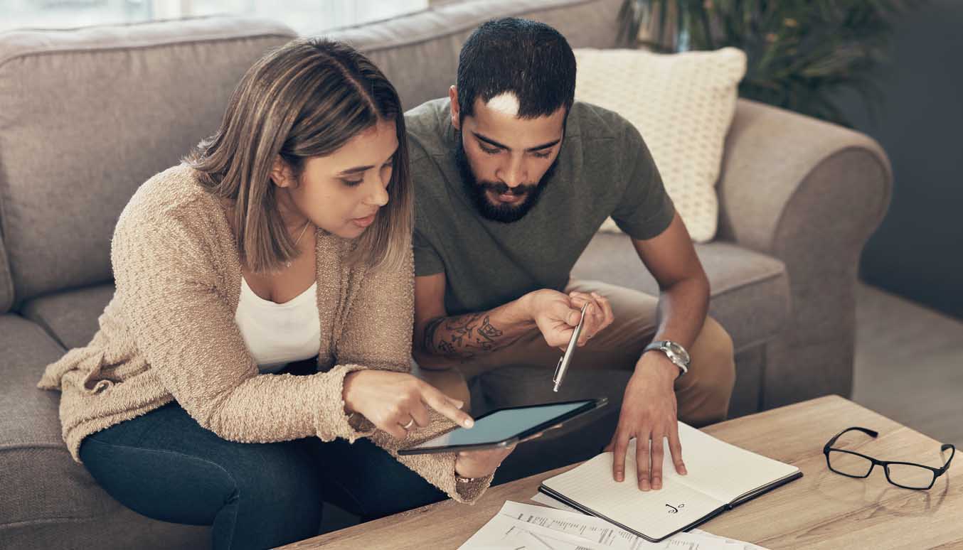 Young couple looking at figures on tablet