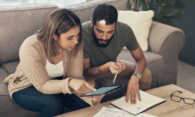 Young couple looking at figures on tablet