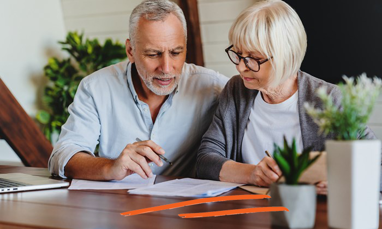 Older couple discussing at kitchen table