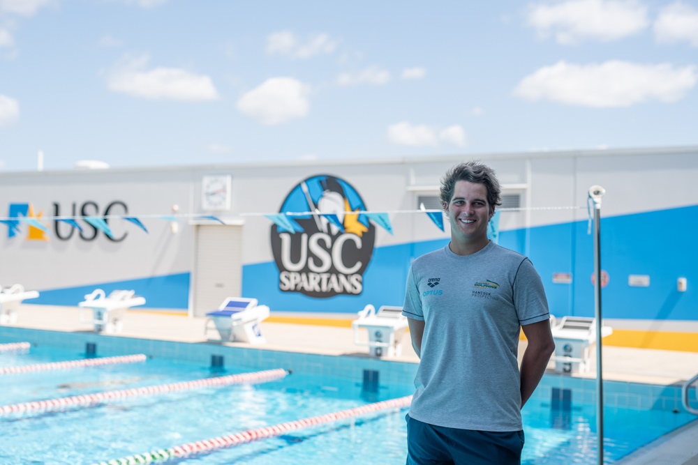 Swimmer standing next to a pool